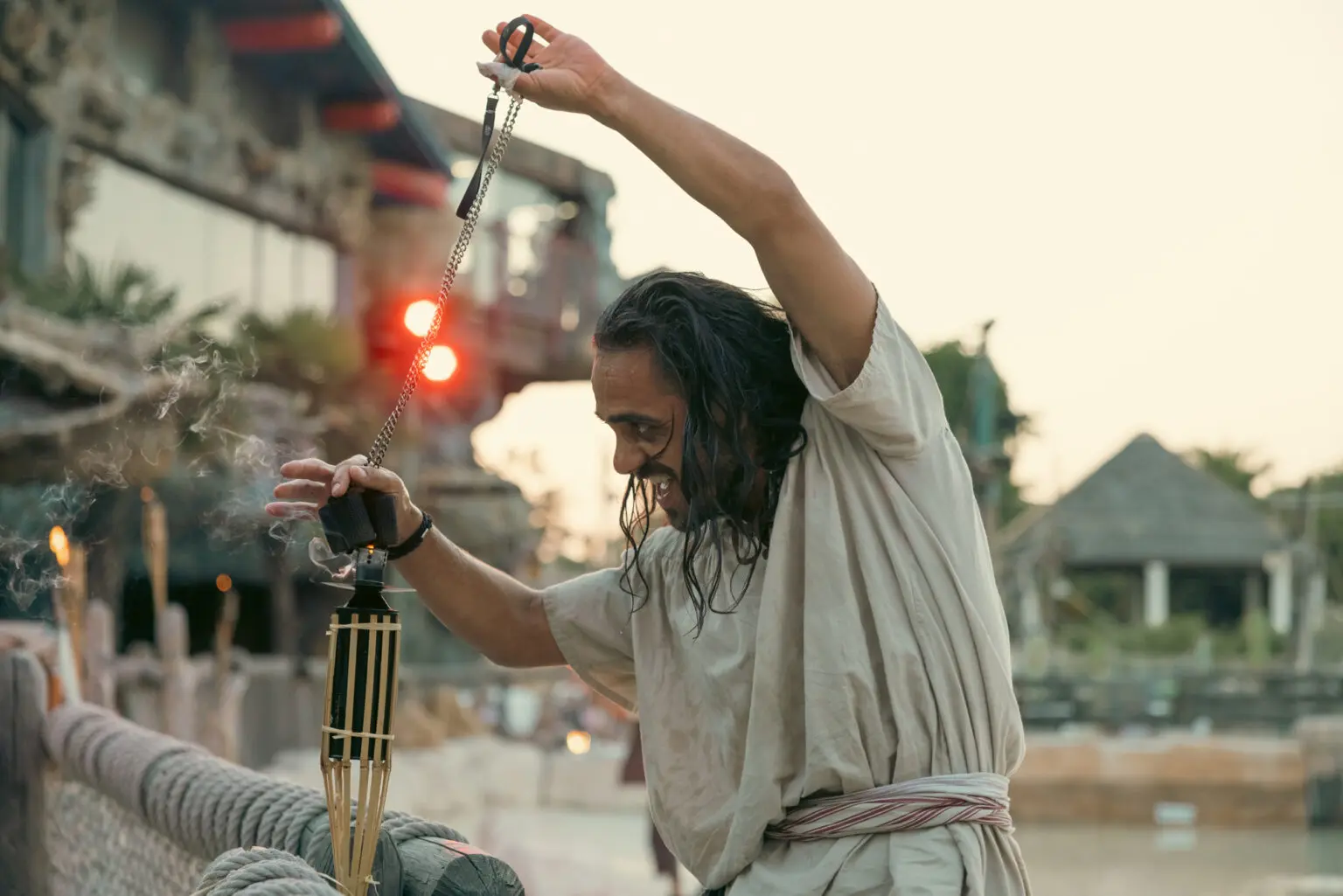 Acteur qui allume un flambeau au diner spectacle pirate