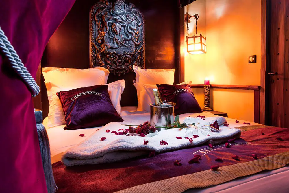 Lit avec rose et champagne dans une suite Privilège à l'hôtel Cap Pirate